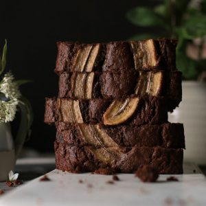 Double Chocolate Banana Bread stacked on it's side on a cutting board.