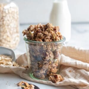 Egg white granola in a jar, on a staged table top.