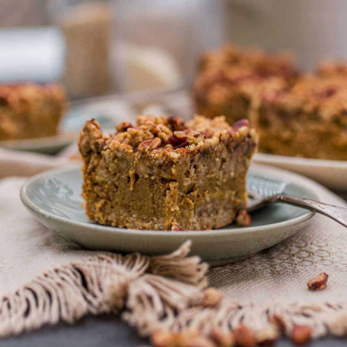 a slice of pumpkin pecan pie bar on a blue plate and a fork beside.