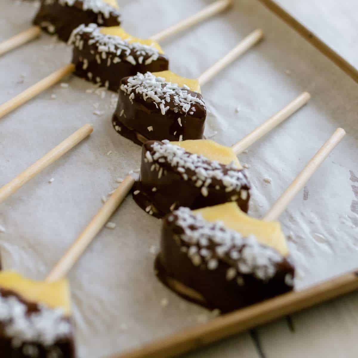 Recipe steps 4, place the chocolate-dipped pineapple on a baking sheet with parchment paper on it and sprinkle shredded coconut on top.