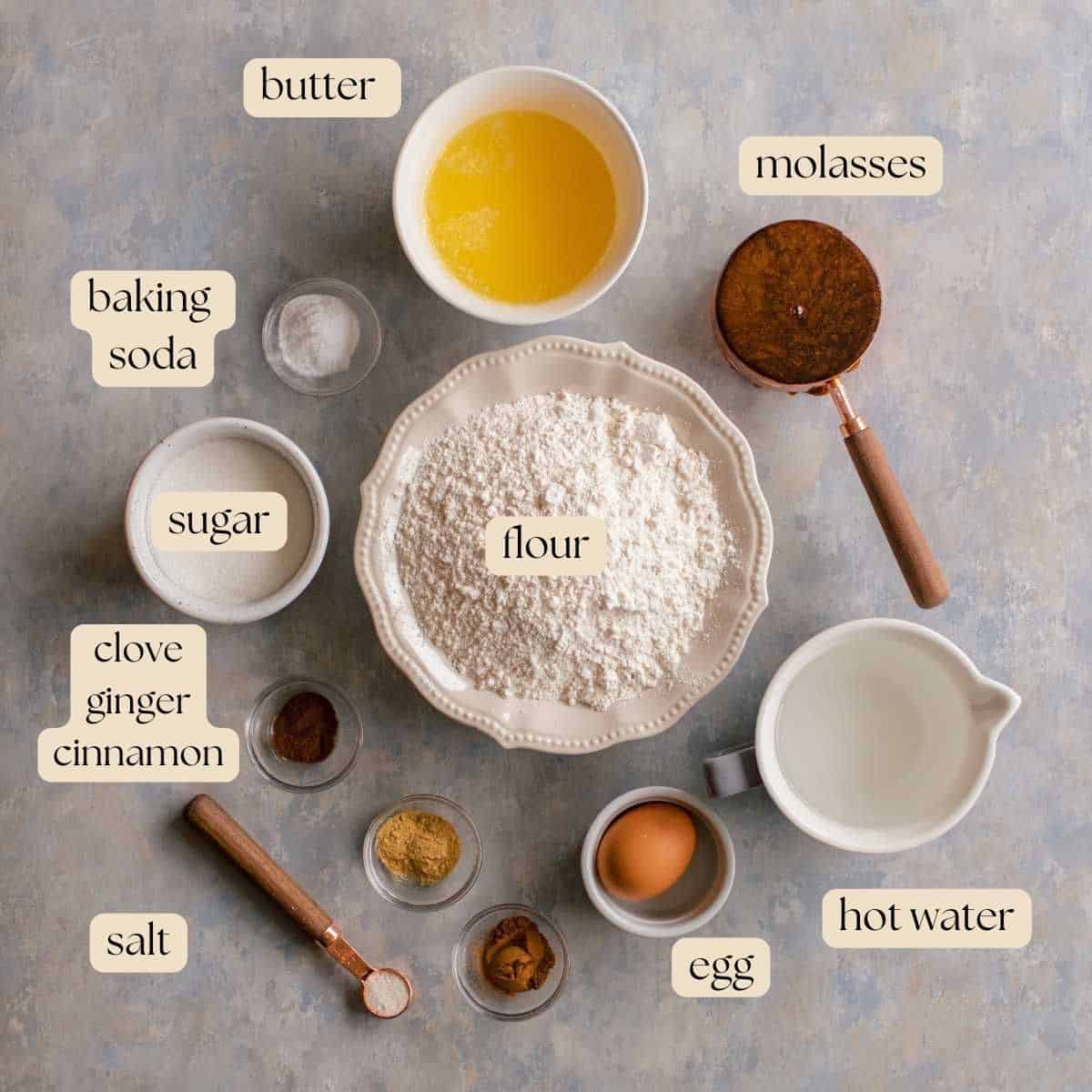 Ingredients to make gingerbread bundt cake in measuring spoons, pinch bowls, bowls and measuring cups.