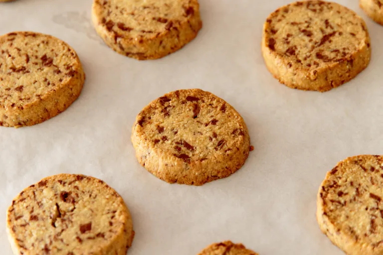 Milk chocolate barley cookies on parchment paper.