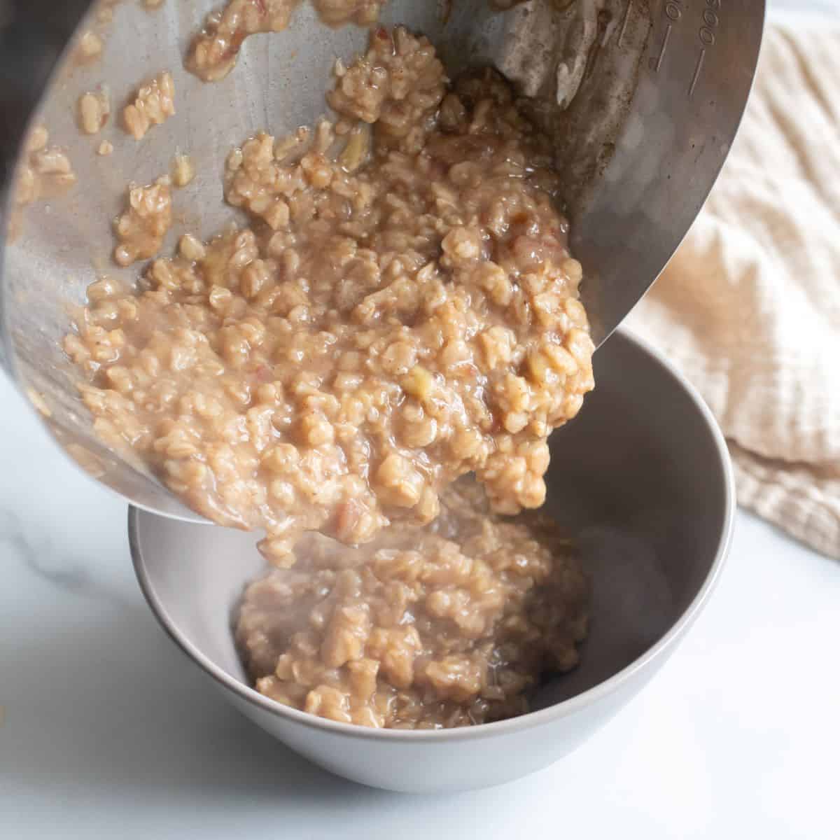 Date oatmeal pouring into a bowl from a metal pot.