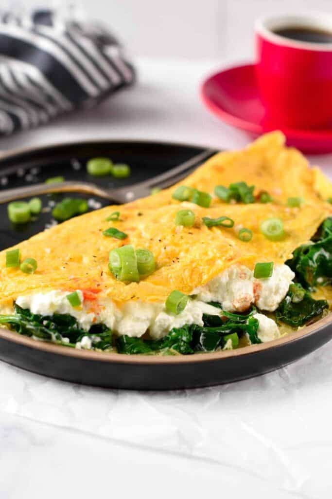 Omelet with cottage cheese and greens inside.
