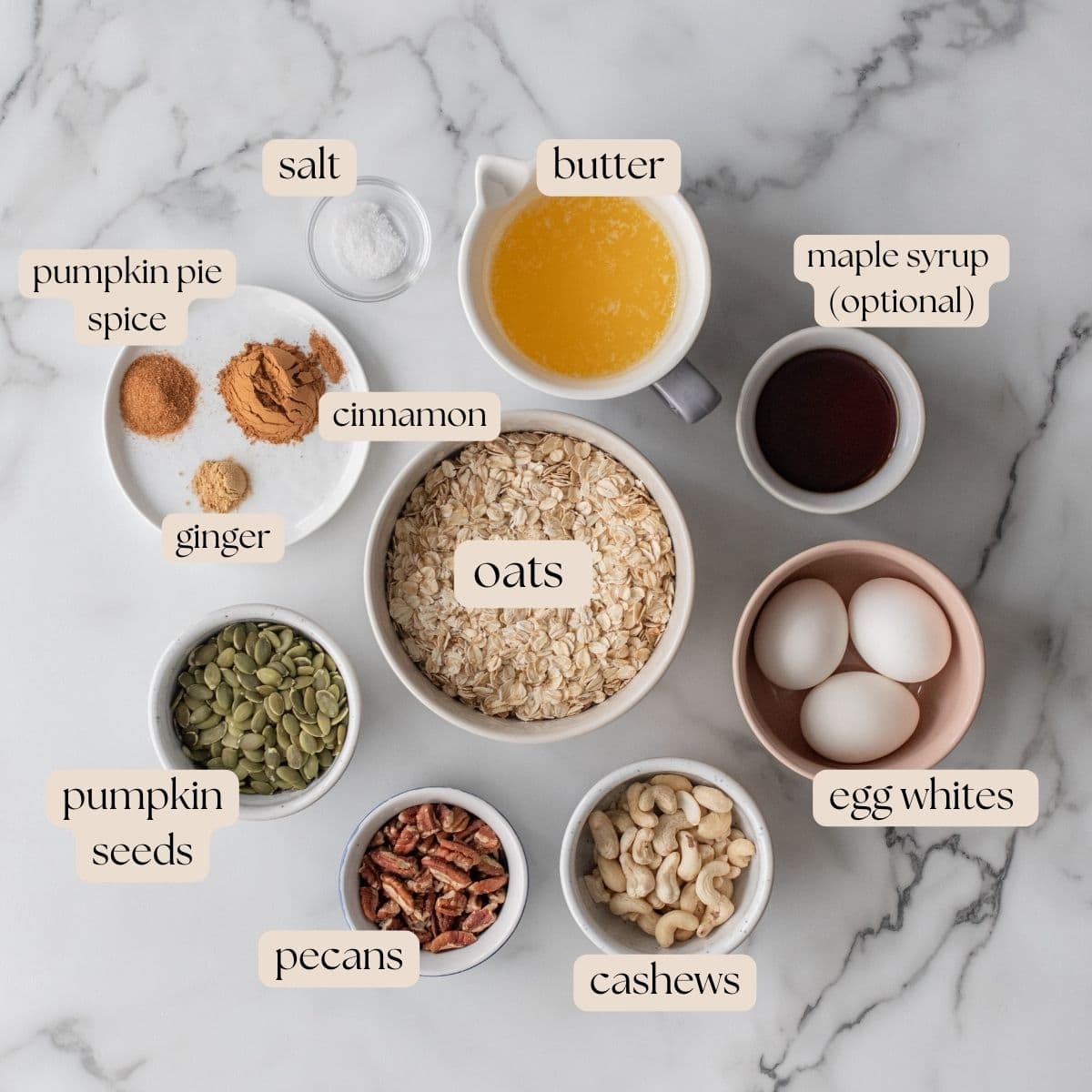 Ingredients to make egg white granola in mixing bowls and pinch bowls.