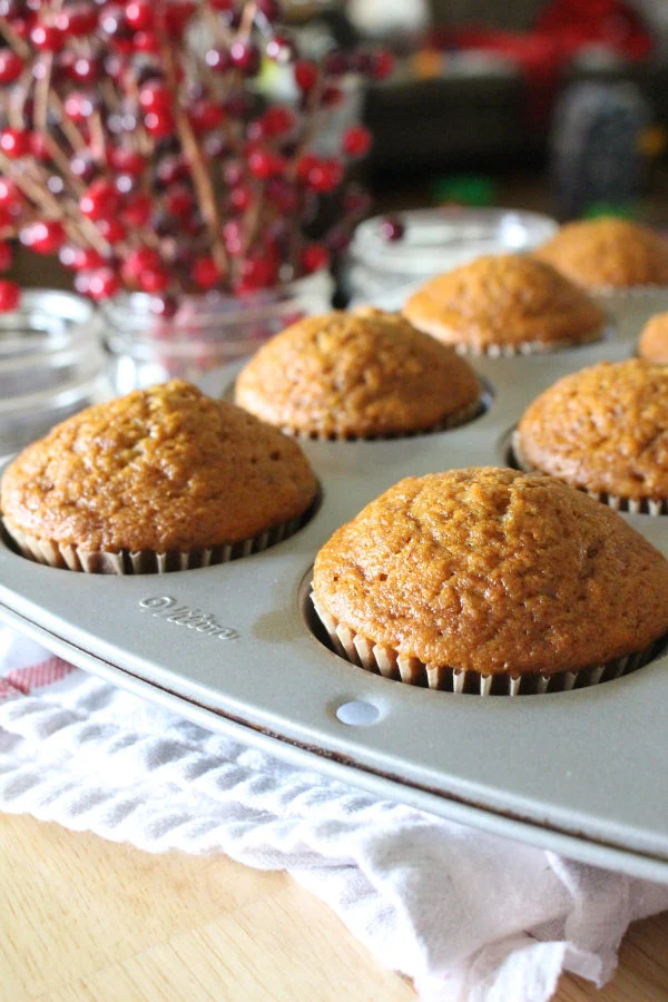 Muffin tin full of banana bread muffins in a bright kitchen.