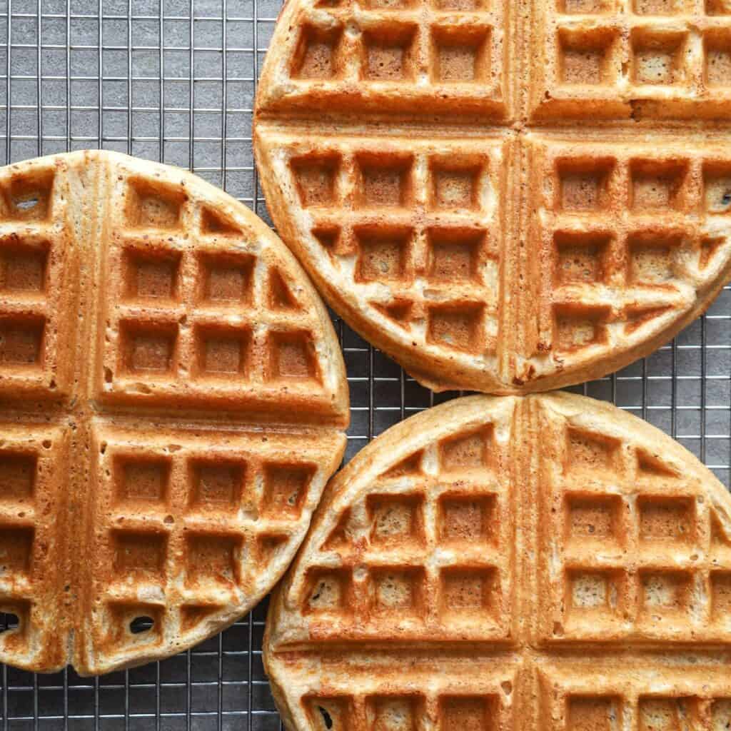 Close up of three einkorn waffles on a cooling rack.